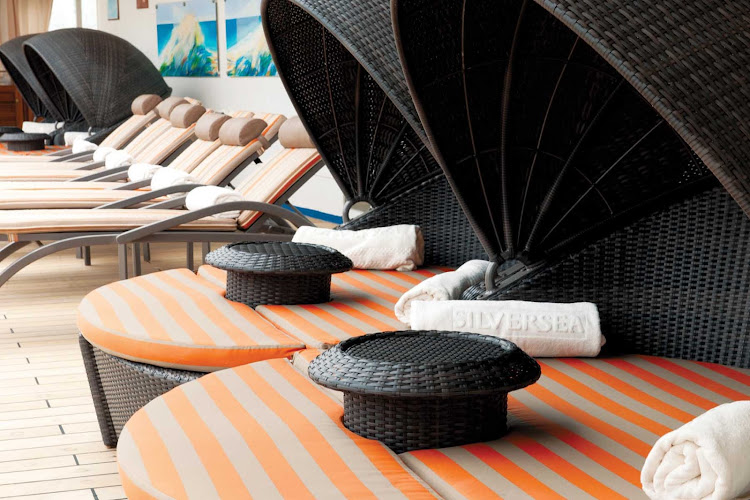 The pool deck aboard Silver Shadow features teak lounge chairs in the shade and sun, multiple bubbling whirlpools and a pool.