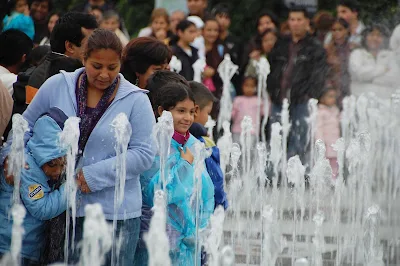 Locals surround a water sculpture in Lima, Peru. 