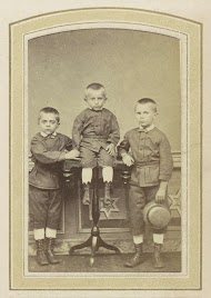 Portret van drie kinderen in pakjes en laarzen