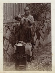 Chinese kapper scheert een klant op straat