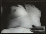 Borst en buik van een liggende, naakte vrouw en de vingers van haar linker hand