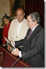 El alcalde, a la derecha, da lectura a la leyenda de la placa entregada al policía jubilado, en presencia de su esposa.