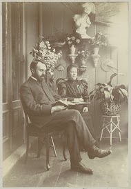 Vrouw en lezende man, zittend in een serre