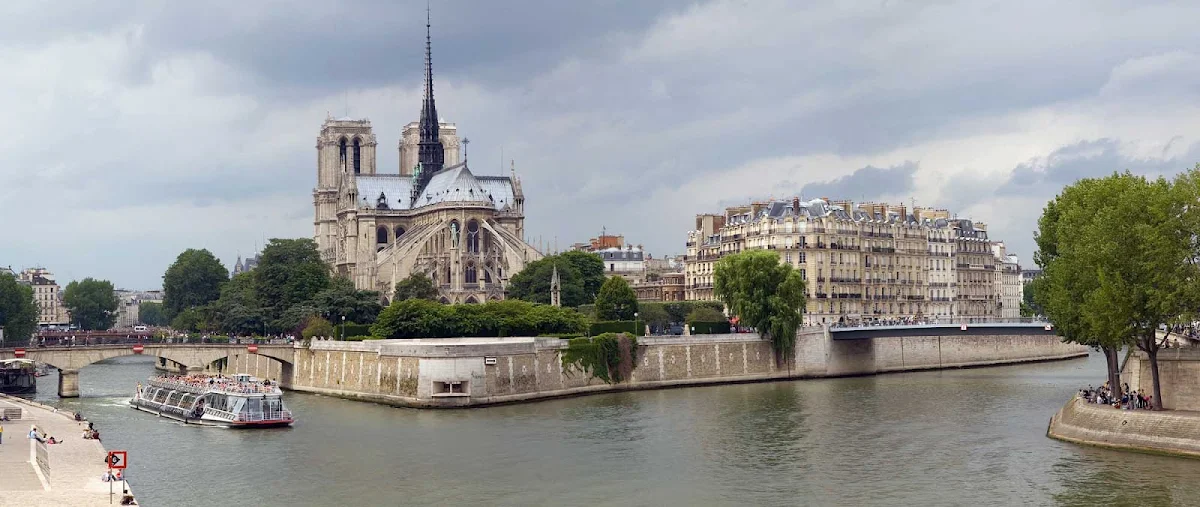 Notre-Dame-river-cruise-Paris - A river cruise ship sails past Notre Dame de Paris on Ile de la Cite in Paris.
 
