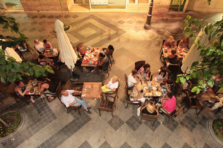 Locals and visitors in the coastal town of Beniform, in the province of Alicante, Spain, enjoy conversation and tapas, delicious small-plate dishes. 