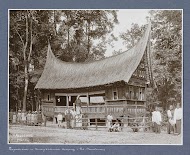 Mannen, vrouwen en kinderen poserend voor een vergaderhuis in Minangkabou op Sumatra