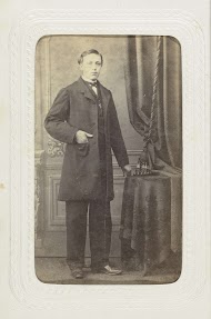 Studioportret van een man staand aan tafel bij een achtergronddoek