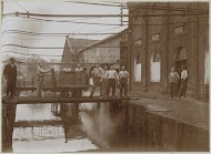 Werknemers in de weer met een geladen kar bij een watertje