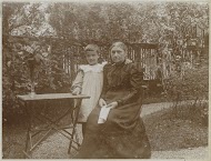 Vrouw met een kind bij een tafel in een tuin