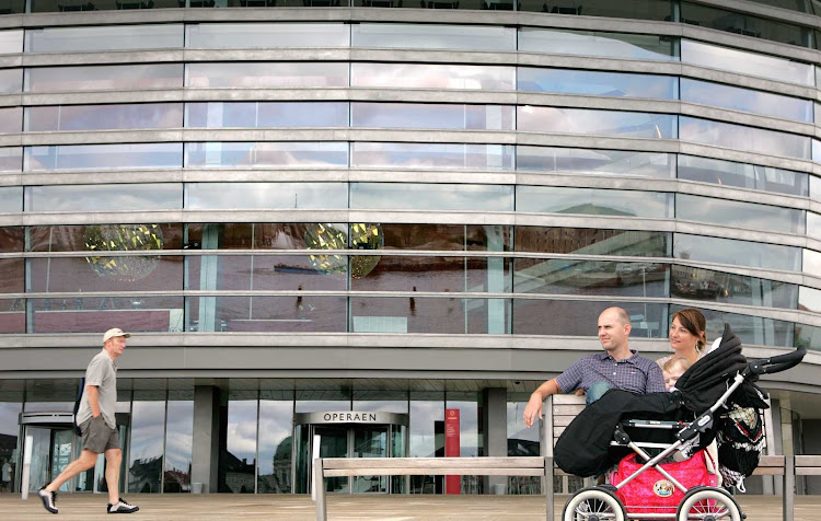 A family pauses in front of the Opera House in Copenhagen, Denmark.