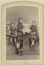 Portret van vijf kinderen bij een muurtje