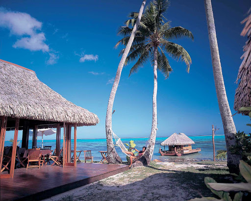 A relaxing scene at L'hôtel Fare Vai Moana in Papetoai, Mo'orea. Lodging on Mo'orea can include bungalows close to glistening white beaches.