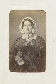 Studioportret van een oudere vrouw in een lange, bolle zwarte jurk