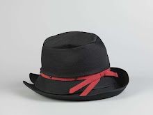 Hoed van zwart doorgestikt satijn versierd met een rood ripslint en zwarte gitten. Samen met hoedendoos van La femme chic Amsterdam.